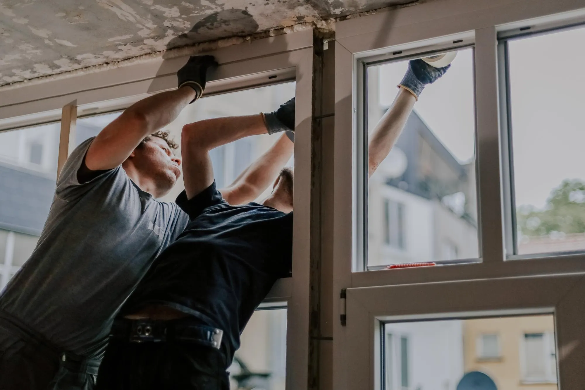 Worker installing a new window in a residential home Worker installing a new window in a residential home